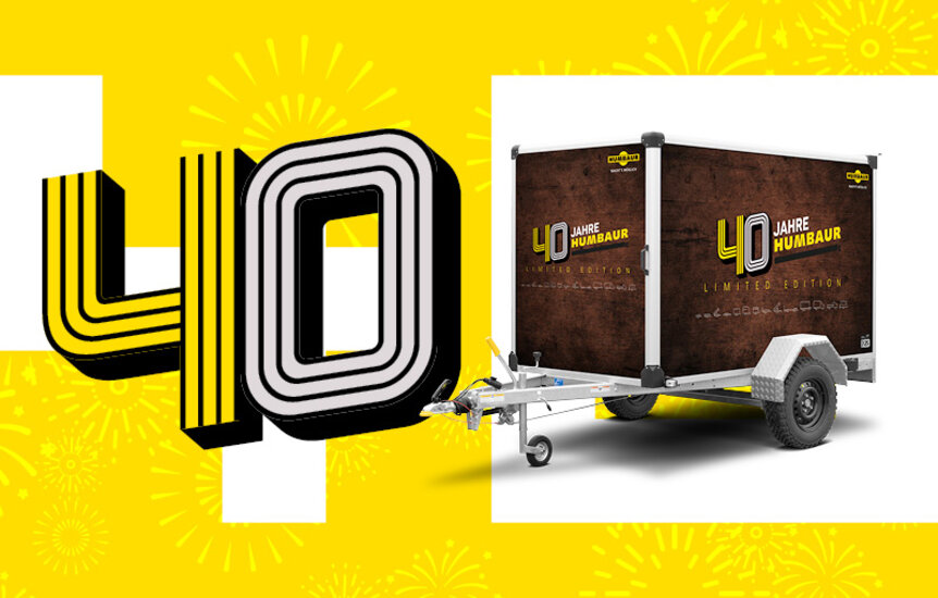 Humbaur Kofferanhänger in Jubiläumsdesign neben Schriftzug 40 Jahre | © Humbaur GmbH