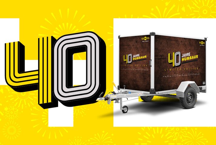 Humbaur Kofferanhänger in Jubiläumsdesign neben Schriftzug 40 Jahre | © Humbaur GmbH