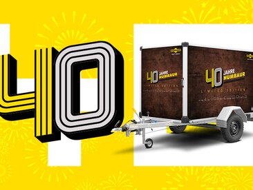Humbaur Kofferanhänger in Jubiläumsdesign neben Schriftzug 40 Jahre | © Humbaur GmbH