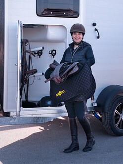 Reiterin vor Humbaur Pferdeanhänger mit Sattel und Schabracke  | © Humbaur GmbH