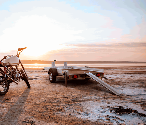 KFT Kleinfahrzeugtransporter neben Motorrad am Strand | © Humbaur GmbH