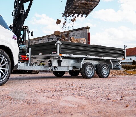 HTK, Ein Humbaur Dreiseitenkipper, der von einem Bagger mit Material beladen wird  | © Humbaur GmbH