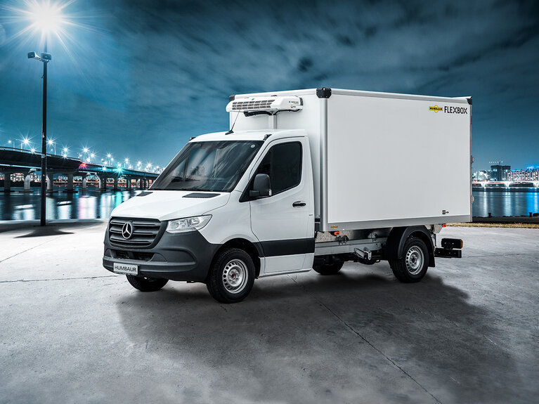 Fahrzeug mit Humbaur Flexbox-Aufbau steht auf einer beleuchteten Straße vor einer Brücke. | © Humbaur GmbH