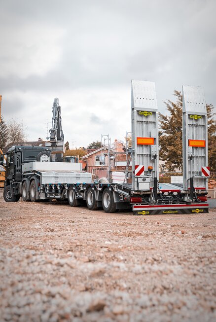 LKW mit Schwerlastanhänger steht unbeladen in einer Baustelle. | © Humbaur GmbH