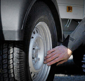 Ein Mann kontrolliert die Reifen eines Anhängers. | © Humbaur GmbH
