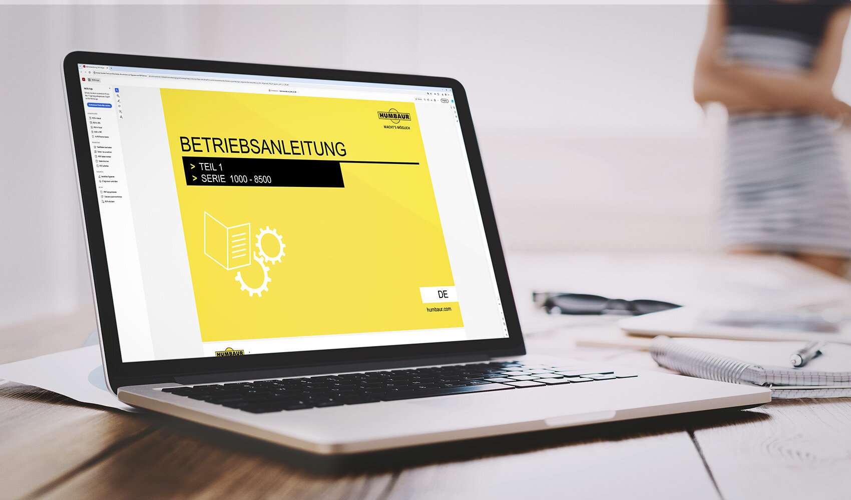 An einem Laptop ist die Bedienungsanleitung eines Humbaur Anhängers geöffnet | © Humbaur GmbH